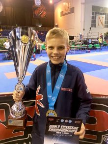 Photo of Liam Holden with trophy and medal.