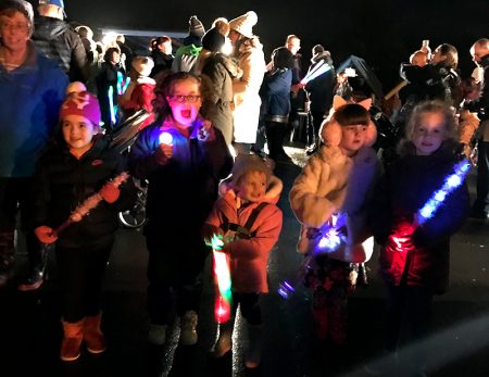 Photo of children holding various lighted toys at the fireworks display.