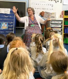 Photo of Ali Smith reading one of her stories to some of the Reception class children.
