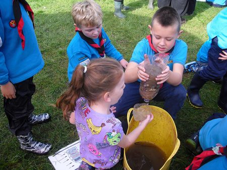Photo of the Beavers building a water filter in a teamwork exercise.
