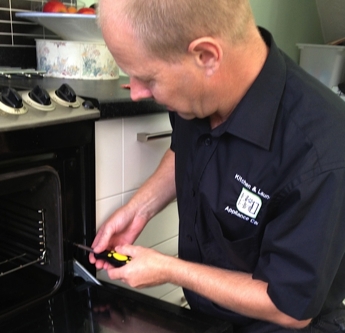 Photo of a domestic appliance repairer at work.