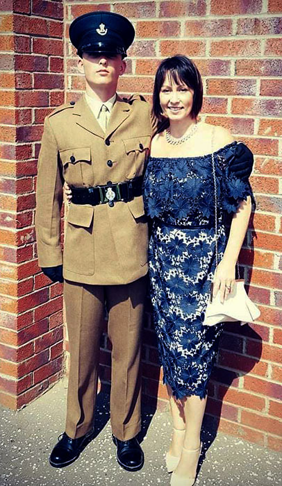Photo of a soldier in uniform and a lady in a dress.