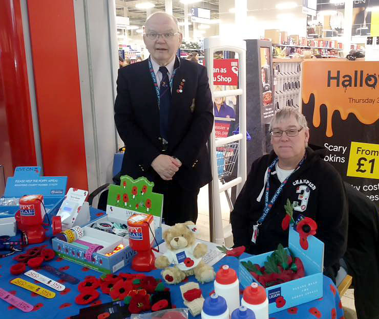 Photo of two Poppy Appeal collectors behind a table.