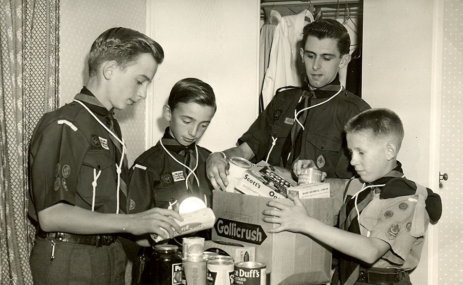 Photo of a group of scouts packing provisions into a cardboard box.