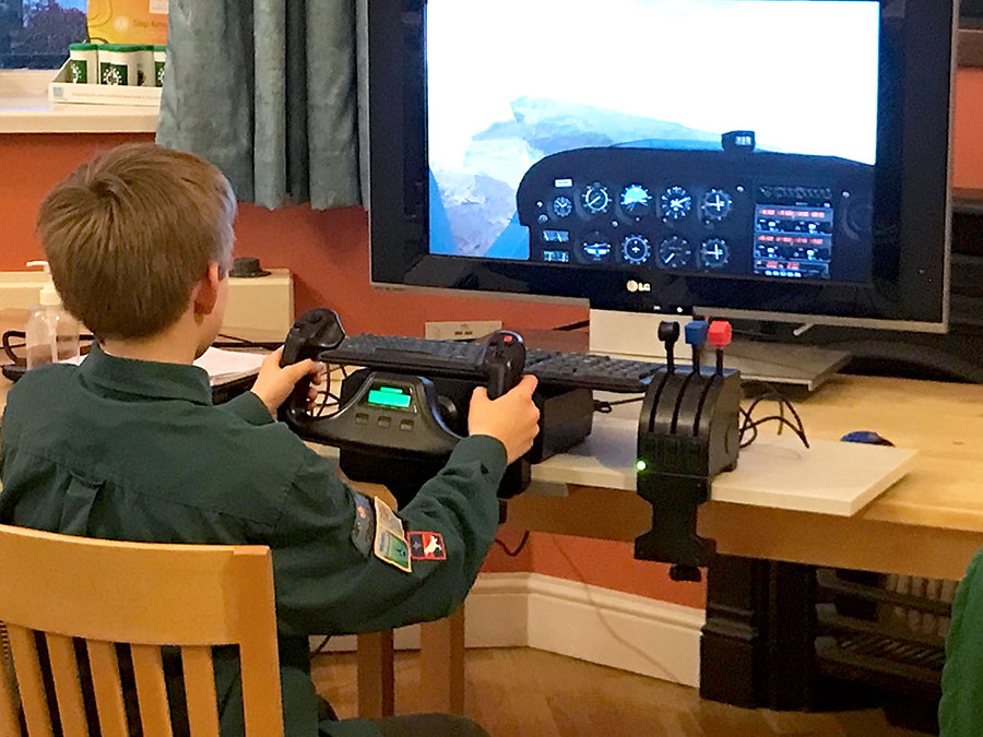 Photo of a Scout using a desktop flight simulator.