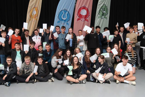 Photo of a group of students holding sheets of paper.