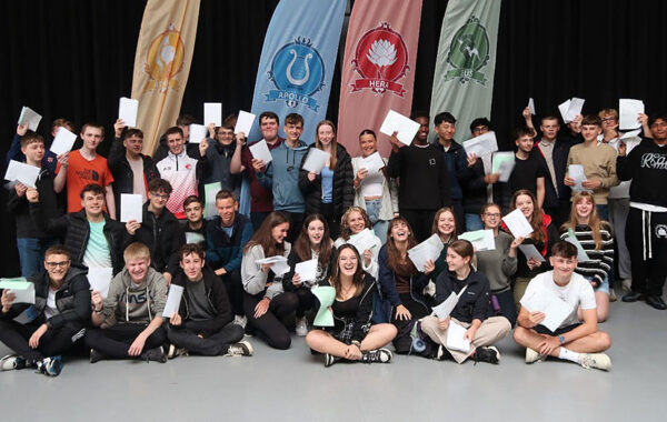 Photo of a group of students holding sheets of paper.