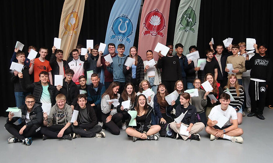 Photo of a group of students holding sheets of paper.