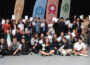 Photo of a group of students holding sheets of paper.