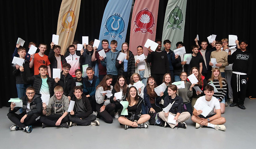 Photo of a group of students holding sheets of paper.