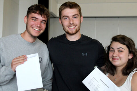 Photo of a group of students holding envelopes.